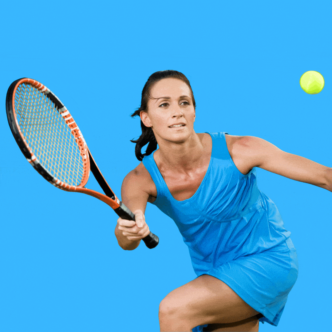 A woman hits a tennis ball with a racket.