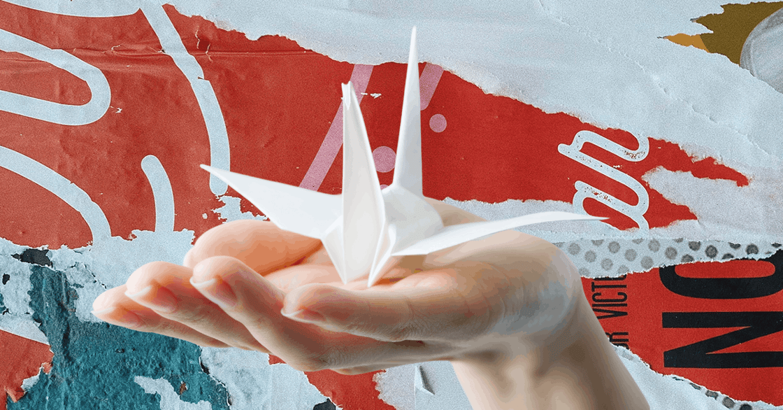 A hand holding a paper crane.