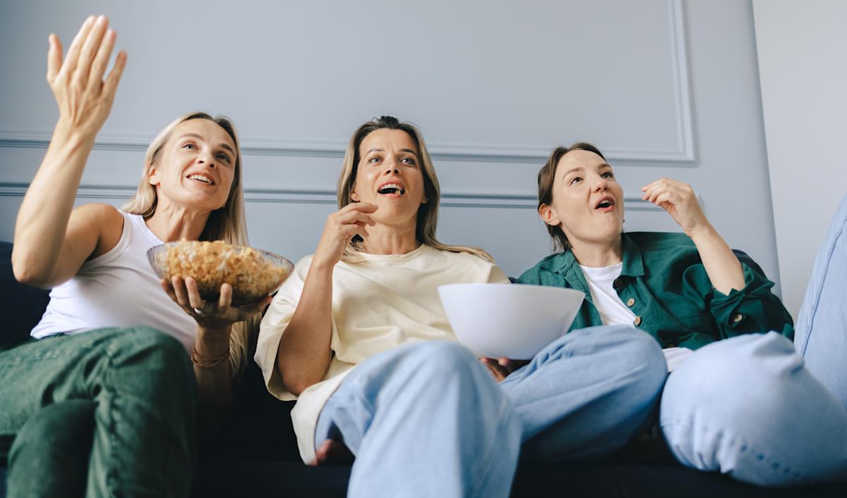 Friends watch TV together on the couch