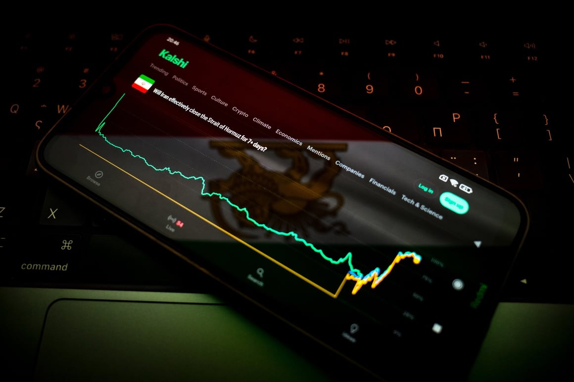 A smartphone displaying the Kalshi prediction market app open to a question about the Strait of Hormuz, resting on a keyboard.