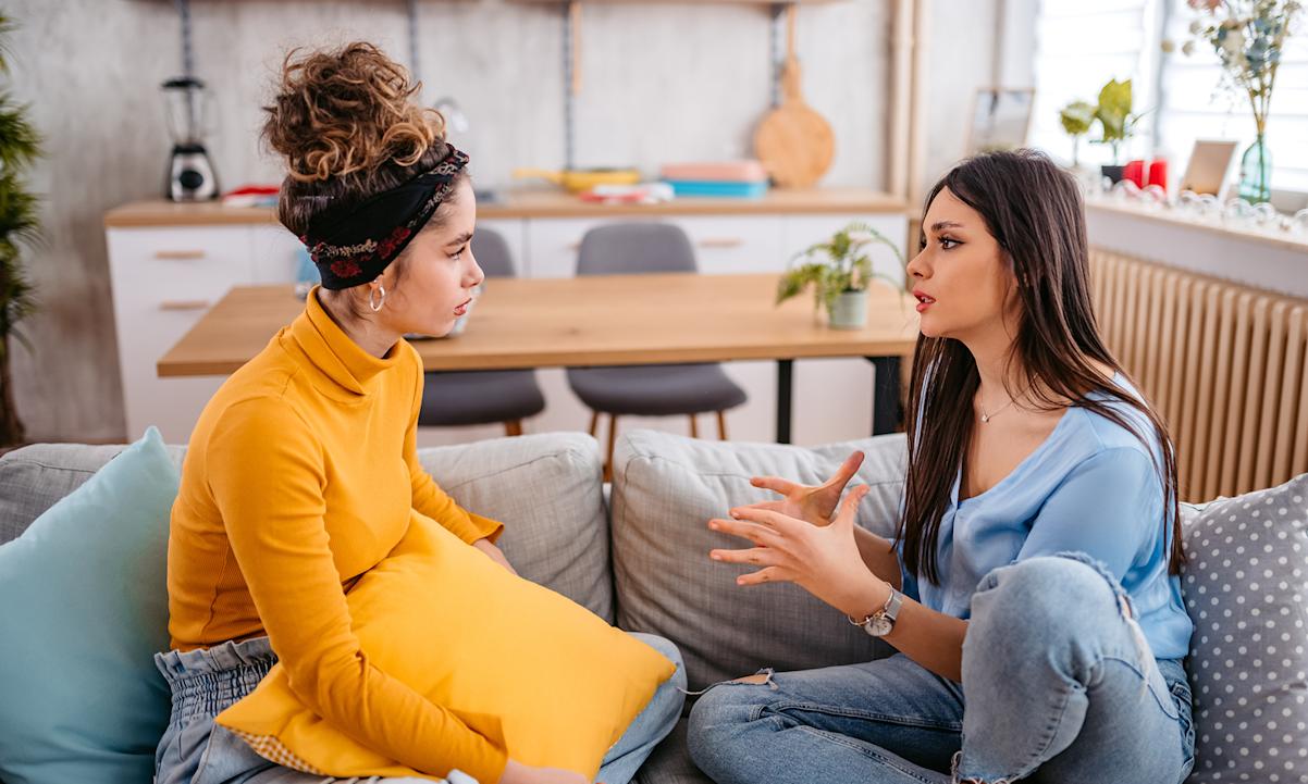 Two women arguing on a couch